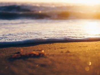 Close-up of sand at beach against sky