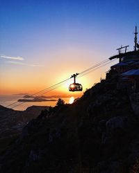 Overhead cable car against sky during sunset