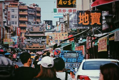 People in market against buildings