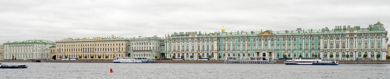 Buildings in city against cloudy sky