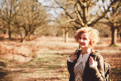 Woman standing on tree trunk