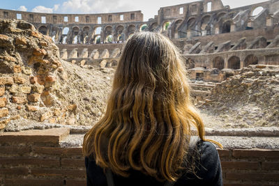 Rear view of girl with long hair at colosseum