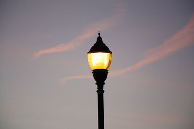 Low angle view of street light against sunset. 