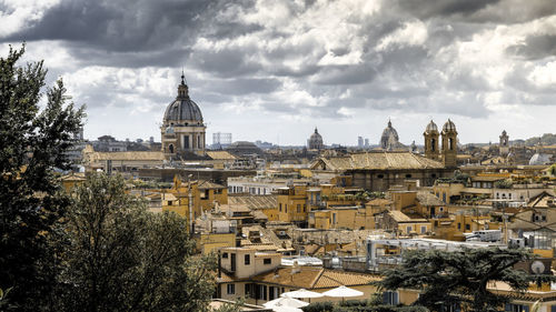 View of buildings in city against cloudy sky