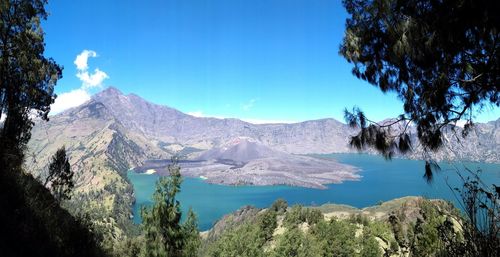 Scenic view of lake and mountains against blue sky