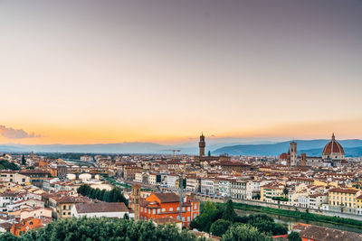 Mid distance view of florence cathedral against sky in city during sunset