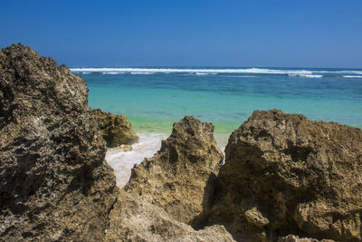 Rock formation on beach against sky