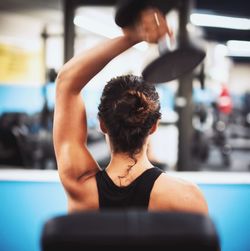 Rear view of woman with arms raised