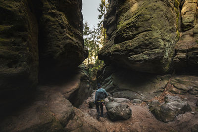 Rear view of man standing by rock formation