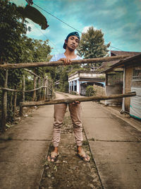 Portrait of young woman standing on footbridge