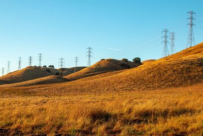 Electricity pylon on field against sky