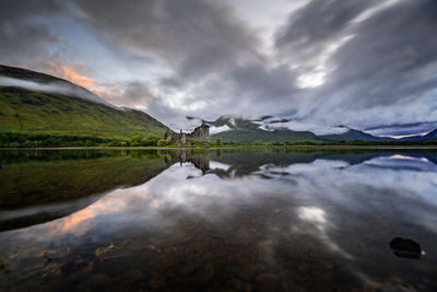 Scenic view of lake by mountain against sky