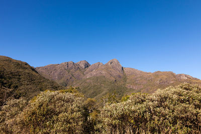 Scenic view of mountains against clear blue sky