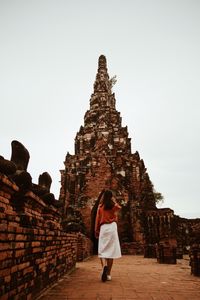 Rear view of woman at temple against sky