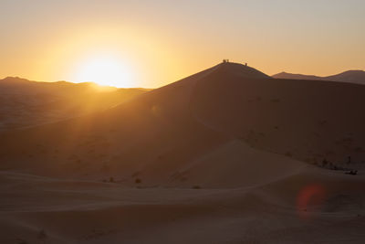 Scenic view of desert against sky during sunset