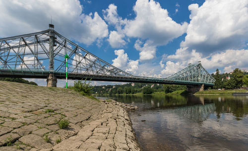 Low angle view of bridge over river against sky