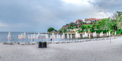 Panoramic view of beach by sea against sky in city