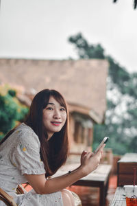 Portrait of young woman sitting outdoors