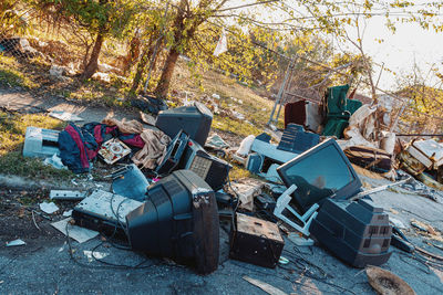 Abandoned garbage can against trees