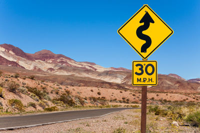 Road sign against blue sky