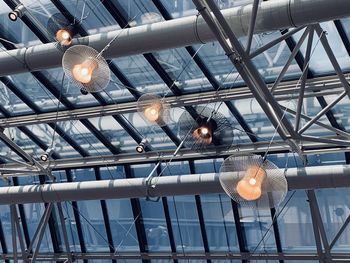 Low angle view of illuminated pendant lights hanging from ceiling