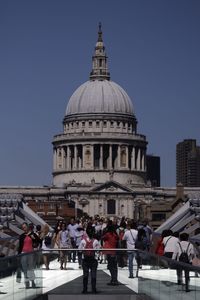 People on footbridge against st pauls cathedral 
