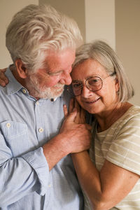 Portrait of senior couple sitting on sofa at home