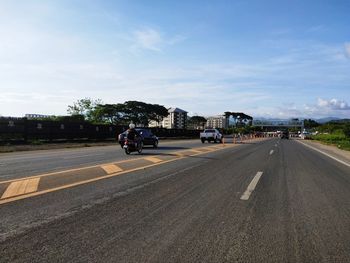 Road by city against sky