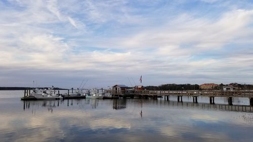 Sailboats moored in sea against sky