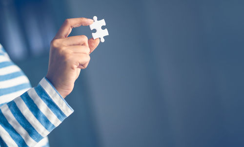 Close-up of man holding hands over blue background