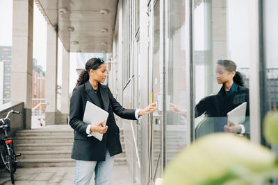 Businesswoman putting keycode to open office door