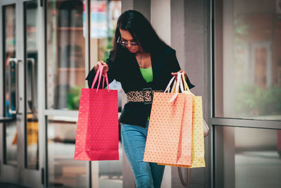 Midsection of woman holding umbrella standing at store