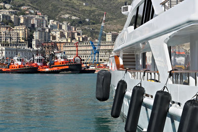 Boats in sea against buildings in city