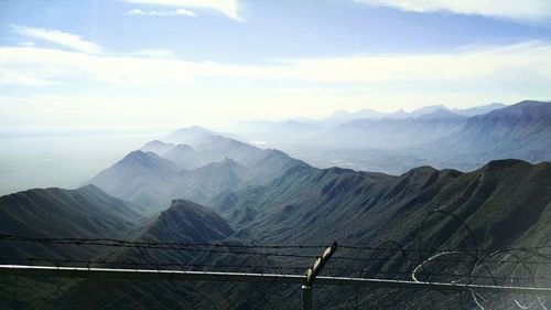 Chainlink fence against majestic mountains