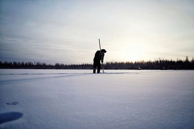 Man standing on snow covered field against sky