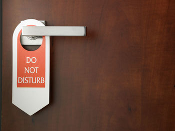 Close-up of do not disturb sign hanging on door handle