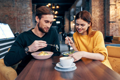 Young couple sitting on table at cafe