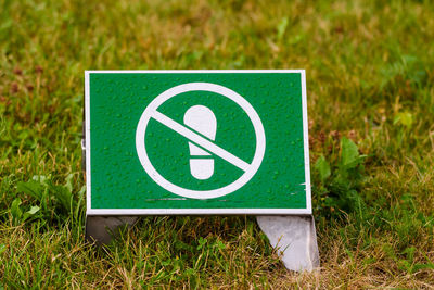 No walking sign on the grass in park.