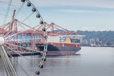 Cranes at commercial dock against sky