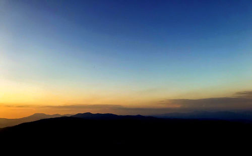 Scenic view of silhouette mountains against sky during sunset