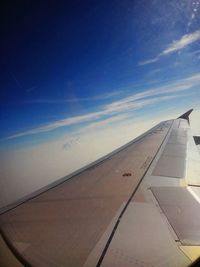 Cropped image of airplane flying over clouds