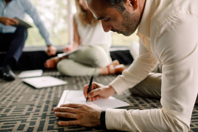 Businessman writing on paper during conference at convention center