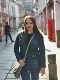 Portrait of smiling woman standing on street in city