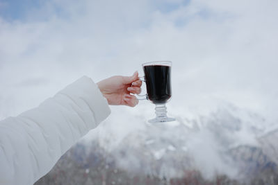 A glass of mulled wine on the top of a mountain in the snow in winter. high quality photo