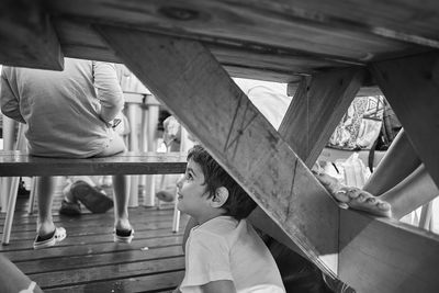 Cute boy looking up while sitting below table