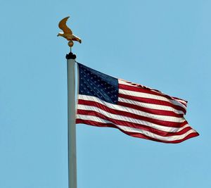 Low angle view of flag against clear blue sky