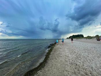 People on beach against sky