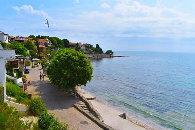 Scenic view of sea by buildings against sky