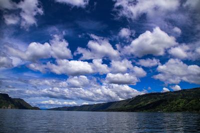 Scenic view of sea and mountains against sky