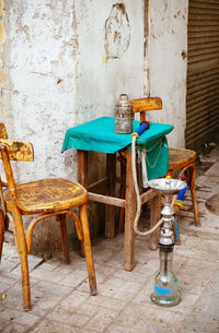 Hookah by wooden chairs and table on footpath